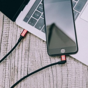 Cable Type-C a Lightning conectado entre un Macbook y un iPhone